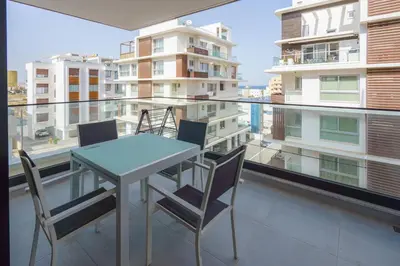 a table and chairs on the balcony of a apartment at Seaview Suite49 steps to Mackenzie Beach Larnaca in Larnaka