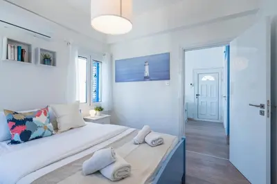 a white bedroom with a large bed with two pillows at Seacret - 1-BR Apartment & Pool in Pyla in Pyla
