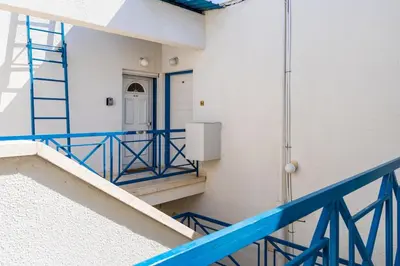 a staircase in a building with a blue railing at Seacret - 1-BR Apartment & Pool in Pyla in Pyla