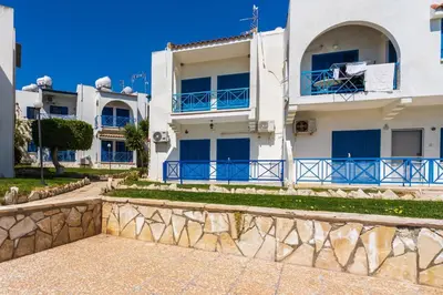 a large white building with blue balconies on it at Seacret - 1-BR Apartment & Pool in Pyla in Pyla