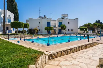 a large swimming pool in front of a building at Seacret - 1-BR Apartment & Pool in Pyla in Pyla