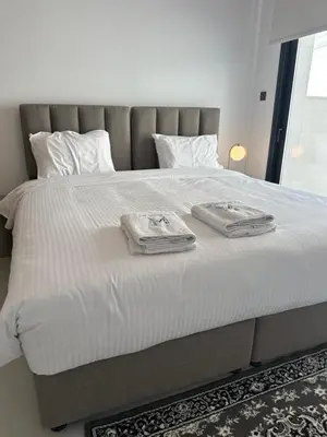 a bed with two towels on top of it at 204 Lux Suites Level2 Tower 206 in Nicosia