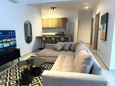 a living room with a large couch and a kitchen at 204 Lux Suites Level2 Tower 206 in Nicosia