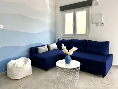 a blue couch in a living room with a table at STAY Napa Ocean Apartment in Ayia Napa