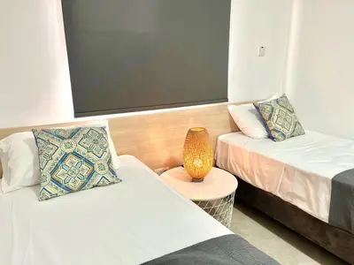 a room with two beds and a table with a lamp at STAY Napa Ocean Apartment in Ayia Napa