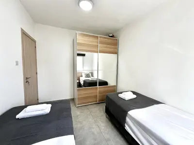 a bedroom with two beds and a closet at STAY Napa Ocean Apartment in Ayia Napa
