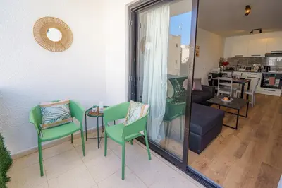 a living room with a couch and a table and chairs at Cozy Apartment in Kapparis # 506 in Paralimni
