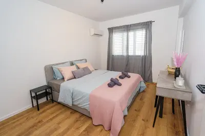 a bedroom with a bed with a pink blanket on it at Cozy Apartment in Kapparis # 506 in Paralimni