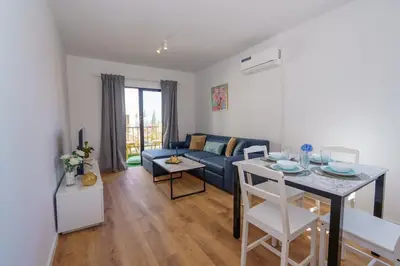 a living room with a blue couch and a table at Cozy Apartment in Kapparis #80 in Paralimni