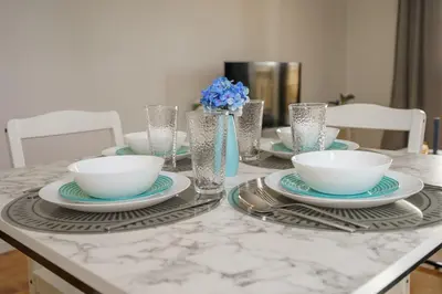 a table with plates and bowls and glasses on it at Cozy Apartment in Kapparis #80 in Paralimni