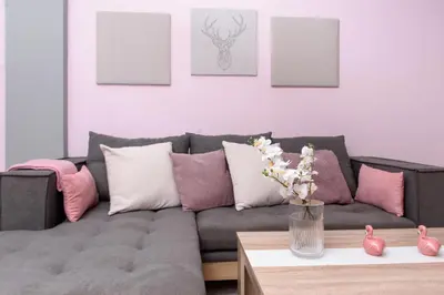 a living room with a gray couch with pink and purple pillows at Azura 3 Bedroom Apartment in Larnaka