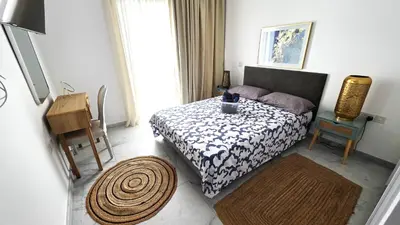 a small bedroom with a bed and a table at Luxurious 2BR Apartment in City Center with Internet in Larnaka