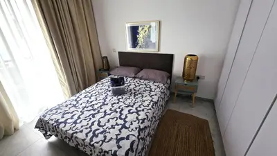 a bedroom with a bed with a black and white blanket at Luxurious 2BR Apartment in City Center with Internet in Larnaka