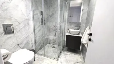 a bathroom with a shower and a toilet and a sink at Luxurious 2BR Apartment in City Center with Internet in Larnaka