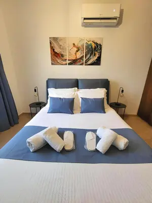 a bed with three pairs of slippers on it at Sunshine Escape in Larnaka