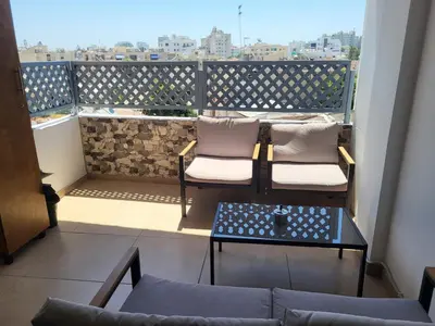 two chairs and a table on a balcony with a view at Sunshine Escape in Larnaka