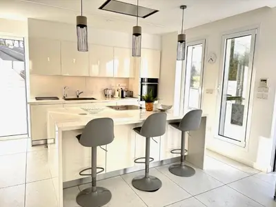 a kitchen with a island with four chairs in it at Sunset Family Villa w heated pool - 1Min Walk to Beach in Protaras
