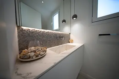a bathroom with a sink and a plate of rocks on a counter at Sunset Family Villa w heated pool - 1Min Walk to Beach in Protaras