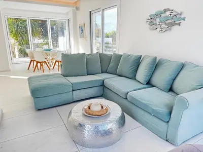 a blue couch in a living room with a table at Sunset Family Villa w heated pool - 1Min Walk to Beach in Protaras