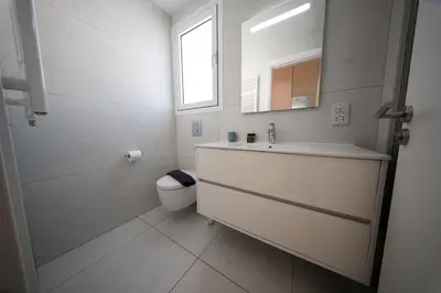 a bathroom with a sink and a toilet and a mirror at Sunset Family Villa w heated pool - 1Min Walk to Beach in Protaras