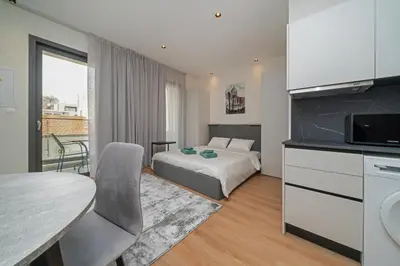 a bedroom with a bed and a kitchen with a table at Luxury Studio in the Heart of Limassol in Limassol