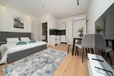 a bedroom with a bed and a table and a dining room at Luxury Studio in the Heart of Limassol in Limassol