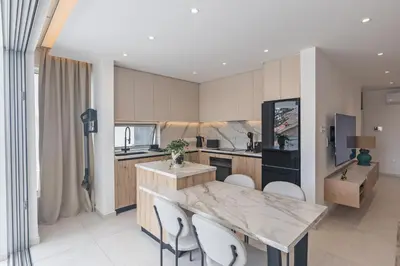 a kitchen with a table and chairs in a room at Mackenzy Dream Residence 202 in Larnaka