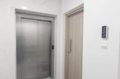 a glass elevator door in a white room at Mackenzy Dream Residence 202 in Larnaka