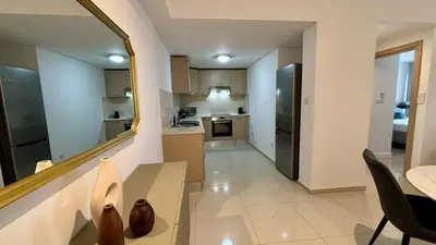 a kitchen with a dining table and a mirror at Zavos Aqua Park Club Apt by TrulyCyprus in Limassol