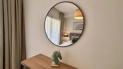 a mirror on a wall above a table in a room at Zavos Aqua Park Club Apt by TrulyCyprus in Limassol