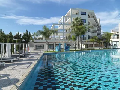 a large swimming pool in front of a building at Zavos Aqua Park Club Apt by TrulyCyprus in Limassol