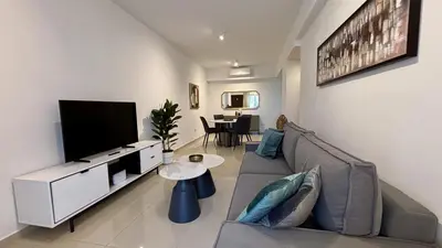 a living room with a couch and a flat screen tv at Zavos Aqua Park Club Apt by TrulyCyprus in Limassol