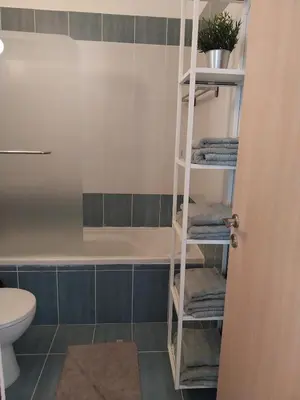 a bathroom with a towel rack next to a bath tub at Modern Holiday Appartment With Pool in Paralimni