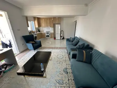 a living room with a blue couch and a table at Park Residence Premium in Larnaka