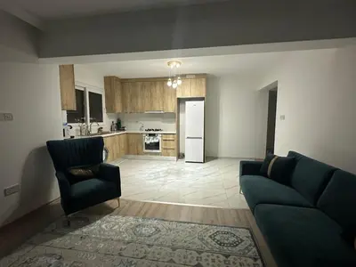 a living room with a couch and a kitchen at Park Residence Premium in Larnaka