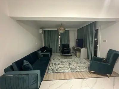 a living room with a blue couch and chairs at Park Residence Premium in Larnaka