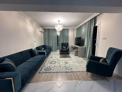 a living room with blue couches and a television at Park Residence Premium in Larnaka