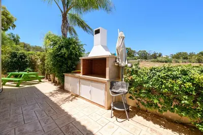 a outdoor kitchen with a grill in a garden at Protaras Holiday Villa - Katia 8B in Protaras
