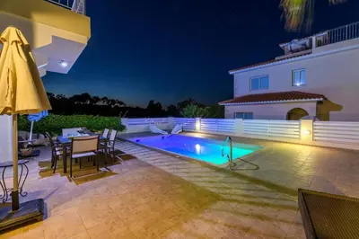 a backyard with a swimming pool at night at Protaras Holiday Villa - Katia 8B in Protaras
