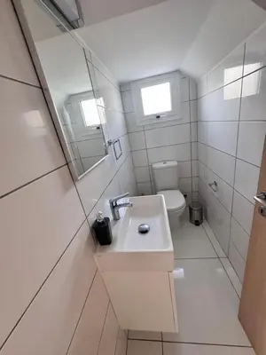 a white bathroom with a sink and a toilet at Nissini Wana Luxury Villa in Ayia Napa