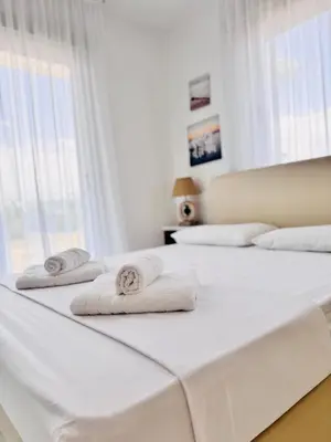 two beds with towels on them in a bedroom at Nissini Wana Luxury Villa in Ayia Napa