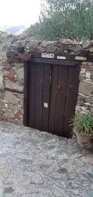a large wooden door in a stone wall at Hatzikyprianou Museum Studio in Lazania