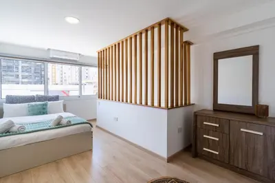 a bedroom with a bed and a mirror and a dresser at Tangerine Modern 1-BR Apartment in Larnaca in Larnaka