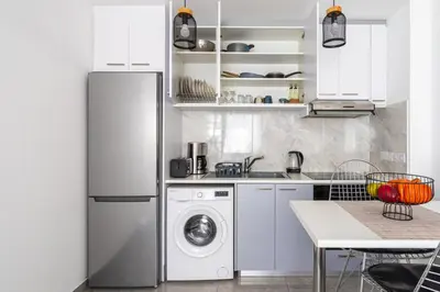 a kitchen with a refrigerator and a washer and dryer at Tangerine Modern 1-BR Apartment in Larnaca in Larnaka