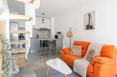 a living room with an orange couch and a kitchen at Tangerine Modern 1-BR Apartment in Larnaca in Larnaka