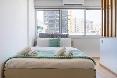 a large bed in a room with a large window at Tangerine Modern 1-BR Apartment in Larnaca in Larnaka