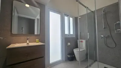 a bathroom with a sink and a shower with a window at STAY Hydra Comfort Apartment in Nicosia