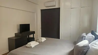 a bedroom with a bed and a tv and towels at STAY Hydra Comfort Apartment in Nicosia