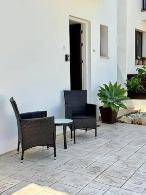 a patio with chairs and a table and a plant at Villa ILIOS Cozy 2BR with Pool in Paralimni