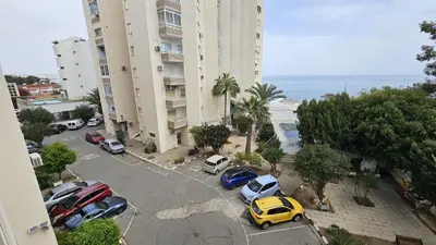 a group of cars parked in a parking lot next to a building at STAY Sea Gate Apartment in Larnaka